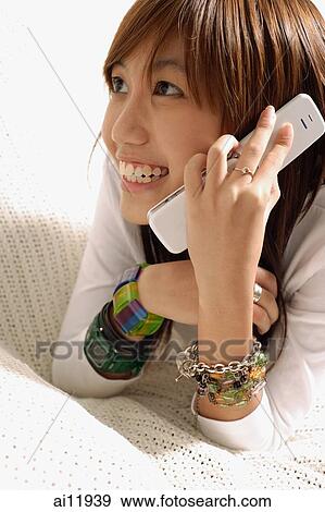 Young woman using mobile phone, smiling View Large Photo Image Stock Photo - Young woman using mobile phone, smiling. Fotosearch