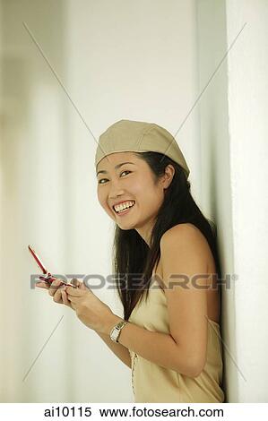 Young woman using mobile phone, smiling View Large Photo Image Stock Photography - Young woman using mobile phone, smiling. Fotosearch