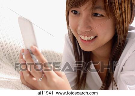 Young woman using mobile phone, text messaging View Large Photo Image Stock Image - Young woman using mobile phone, text messaging. Fotosearch