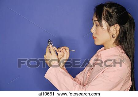 Young woman, using PDA, side view View Large Photo Image Stock Image - Young woman, using PDA, side view. Fotosearch