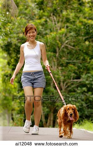 Stock Photo - Young woman walking with her dog. Fotosearch