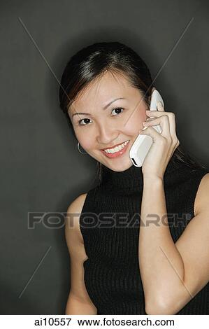 Young woman wearing a black top, using a mobile phone View Large Photo Image Stock Photo - Young woman wearing a black top, using a mobile phone. Fotosearch