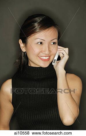Young woman wearing a black top, using a mobile phone View Large Photo Image Stock Photo - Young woman wearing a black top, using a mobile phone. Fotosearch