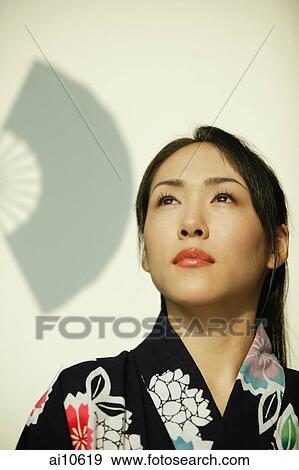 Young woman wearing a kimono, looking up. View Large Photo Image Stock Photo - Young woman wearing a kimono, looking up.. Fotosearch