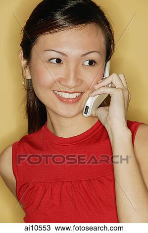 Young woman wearing a red top, using a mobile phone View Large Photo Image Stock Image - Young woman wearing a red top, using a mobile phone. Fotosearch