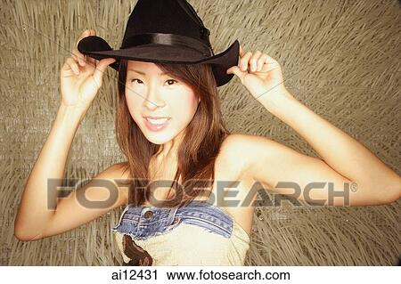 Young woman wearing cowboy hat, looking at camera View Large Photo Image Stock Image - Young woman wearing cowboy hat, looking at camera. Fotosearch