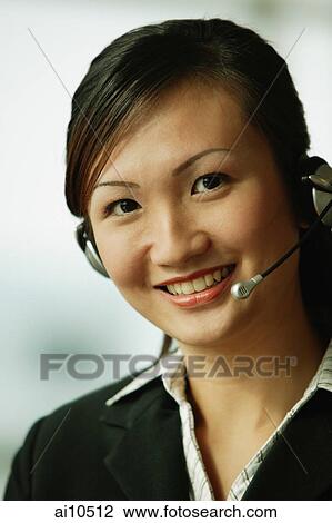 Young woman wearing hands-free device, looking at camera View Large Photo Image Stock Image - Young woman wearing hands-free device, looking at camera. Fotosearch