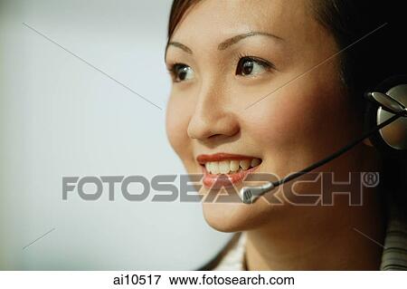 Young woman wearing hands-free device, smiling View Large Photo Image Stock Photo - Young woman wearing hands-free device, smiling. Fotosearch