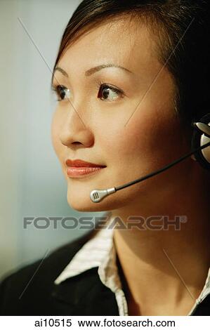 Young woman wearing hands-free device, looking away View Large Photo Image Stock Photography - Young woman wearing hands-free device, looking away. Fotosearch