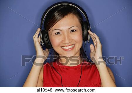 Young woman wearing headphones, smiling View Large Photo Image Stock Photo - Young woman wearing headphones, smiling. Fotosearch