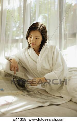 Young woman wearing robe, reading newspaper View Large Photo Image Stock Photo - Young woman wearing robe, reading newspaper. Fotosearch