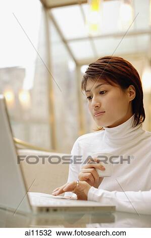 Young woman wearing white turtleneck, using laptop View Large Photo Image Stock Image - Young woman wearing white turtleneck, using laptop. Fotosearch