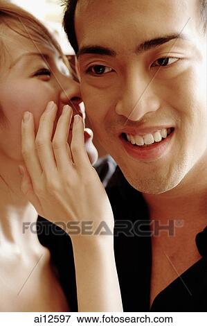 Young woman whispering to young man View Large Photo Image Stock Photo - Young woman whispering to young man. Fotosearch