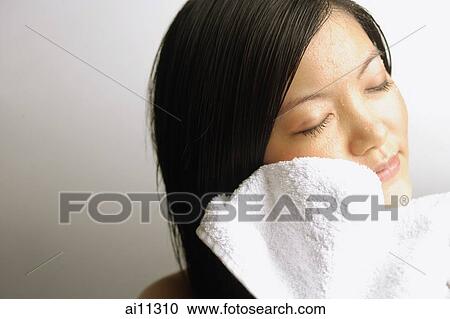 Young woman wiping her face with towel View Large Photo Image Stock Image - Young woman wiping her face with towel. Fotosearch