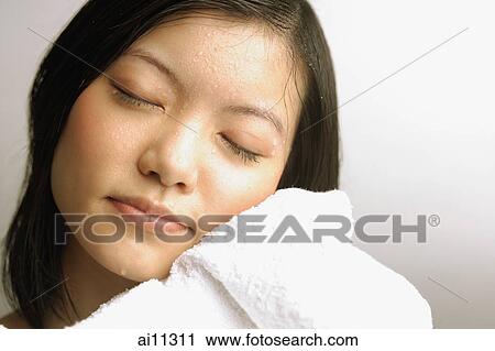 Young woman wiping her face with towel, eyes closed View Large Photo Image Stock Image - Young woman wiping her face with towel, eyes closed. Fotosearch
