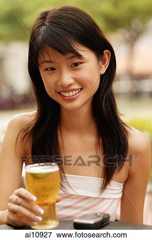 Young woman with a glass of beer, looking at camera View Large Photo Image Stock Photo - Young woman with a glass of beer, looking at camera. Fotosearch