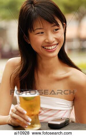 Young woman with a glass of beer, looking away View Large Photo Image Stock Photo - Young woman with a glass of beer, looking away. Fotosearch