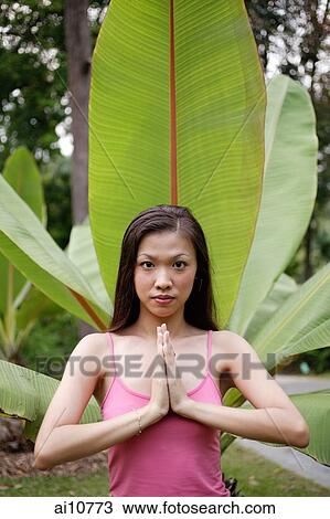Young woman with hands together, looking at camera View Large Photo Image Stock Image - Young woman with hands together, looking at camera. Fotosearch