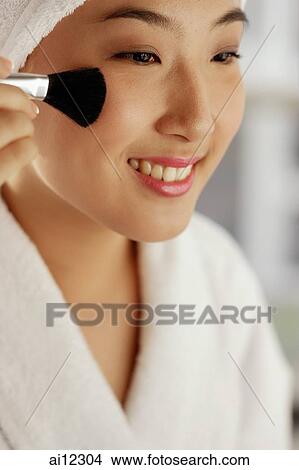 Young woman with make-up brush, smiling View Large Photo Image Picture - Young woman with make-up brush, smiling. Fotosearch