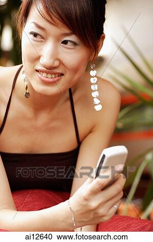 Young woman with mobile phone, looking away View Large Photo Image Stock Image - Young woman with mobile phone, looking away. Fotosearch