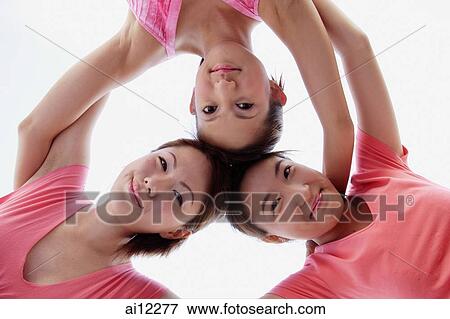 Young women, arms around each other, looking down at camera View Large Photo Image Stock Photo - Young women, arms around each other, looking down at camera. Fotosearch