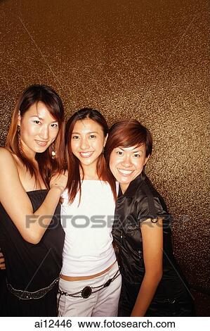 Young women arms around each other, smiling at camera View Large Photo Image Stock Photograph - Young women arms around each other, smiling at camera. Fotosearch