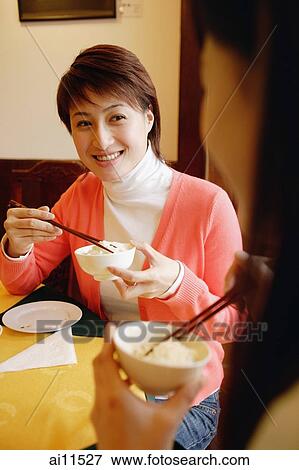Young women eating at a Chinese restaurant View Large Photo Image Stock Photo - Young women eating at a Chinese restaurant. Fotosearch