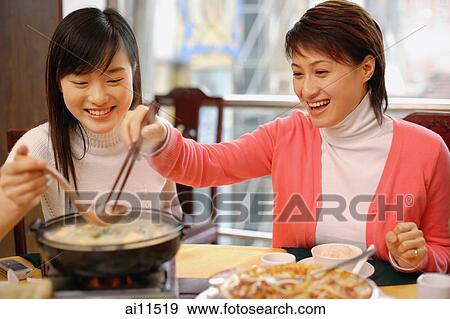 Young women eating at a restaurant View Large Photo Image Stock Photo - Young women eating at a restaurant. Fotosearch