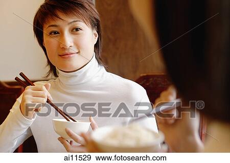 Young women eating rice at a Chinese restaurant. View Large Photo Image Stock Photo - Young women eating rice at a Chinese restaurant.. Fotosearch