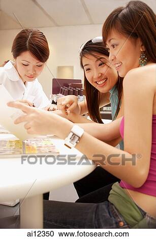 Young women getting a manicure at nail salon View Large Photo Image Stock Image - Young women getting a manicure at nail salon. Fotosearch