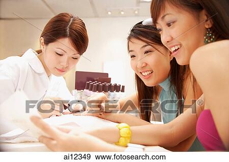 Young women having their nails painted at nail salon View Large Photo Image Stock Photo - Young women having their nails painted at nail salon. Fotosearch