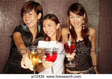 Young women holding drinks, looking at camera View Large Photo Image Stock Photography - Young women holding drinks, looking at camera. Fotosearch