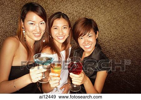 Young women holding drinks, smiling and looking at camera View Large Photo Image Stock Photo - Young women holding drinks, smiling and looking at camera. Fotosearch