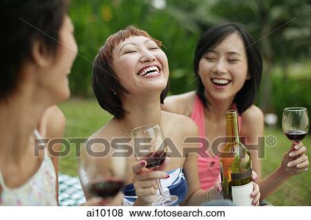 Young women laughing, wine glasses in hand View Large Photo Image Stock Photo - Young women laughing, wine glasses in hand. Fotosearch
