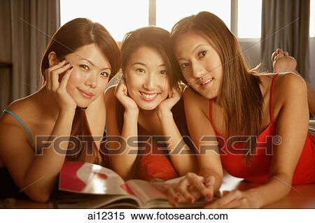 Young women looking at camera, magazine open in front of them, hands on chin View Large Photo Image Stock Photography - Young women looking at camera, magazine open in front of them, hands on chin. Fotosearch