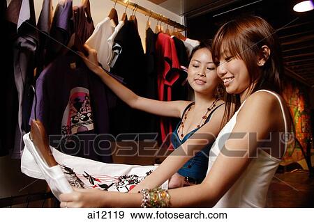 Young women looking at clothes in shop View Large Photo Image Stock Photo - Young women looking at clothes in shop. Fotosearch