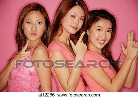 Young women making hand signs, looking at camera View Large Photo Image Stock Photograph - Young women making hand signs, looking at camera. Fotosearch