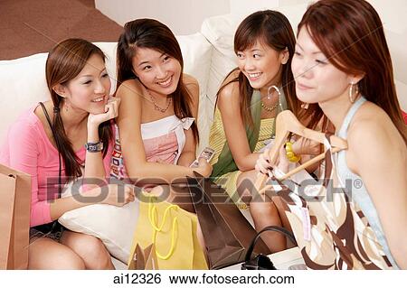 Young women sitting together with shopping bags and clothes View Large Photo Image Stock Photograph - Young women sitting together with shopping bags and clothes. Fotosearch