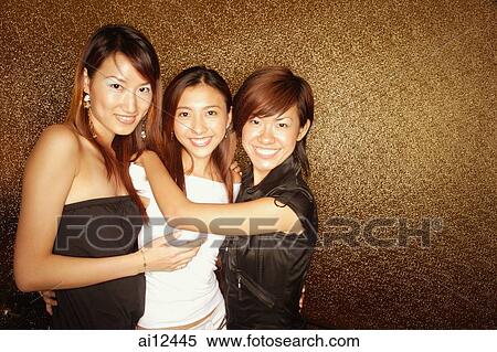 Young women standing side by side, smiling at camera View Large Photo Image Stock Photography - Young women standing side by side, smiling at camera. Fotosearch