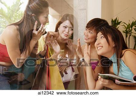 Young women waving at each other through glass window View Large Photo Image Stock Image - Young women waving at each other through glass window. Fotosearch