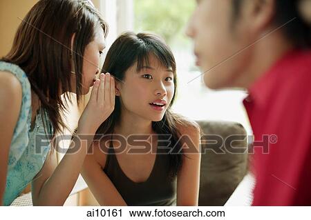 Young women whispering, man in foreground View Large Photo Image Stock Image - Young women whispering, man in foreground. Fotosearch