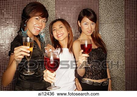 Young women with drinks, smiling and looking at camera View Large Photo Image Stock Photograph - Young women with drinks, smiling and looking at camera. Fotosearch