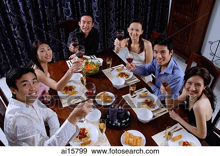 Adults at a dinner party, holding wine glasses, looking up at camera View Large Photo Image Stock Photo - Adults at a dinner party, holding wine glasses, looking up at camera. Fotosearch