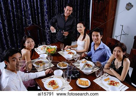 Adults at a dinner party, sitting around table, smiling at camera View Large Photo Image Stock Image - Adults at a dinner party, sitting around table, smiling at camera. Fotosearch