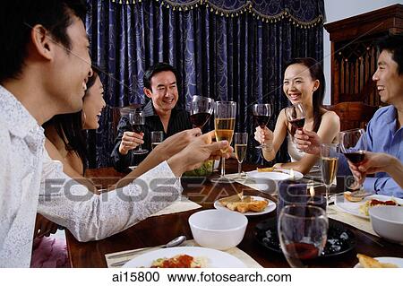 Stock Image - Adults at a dinner party. Fotosearch