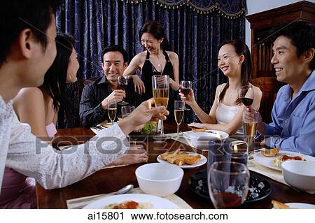 Stock Image - Adults having dinner at home. Fotosearch
