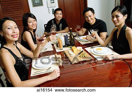 Adults having dinner party, holding drinks, smiling at camera View Large Photo Image Picture - Adults having dinner party, holding drinks, smiling at camera. Fotosearch