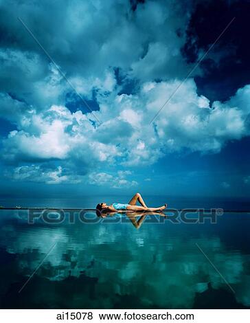 Asian female sunbathing on edge of horizon pool View Large Photo Image Stock Photo - Asian female sunbathing on edge of horizon pool. Fotosearch