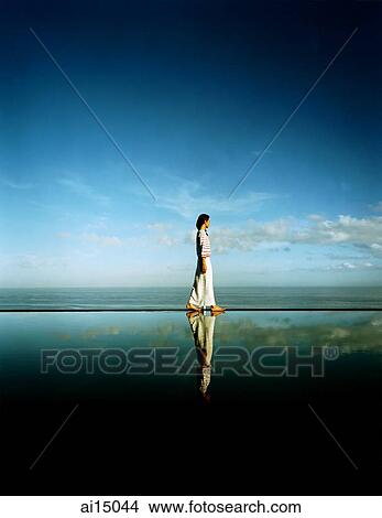 Asian female walking along edge of horizon pool View Large Photo Image Picture - Asian female walking along edge of horizon pool. Fotosearch