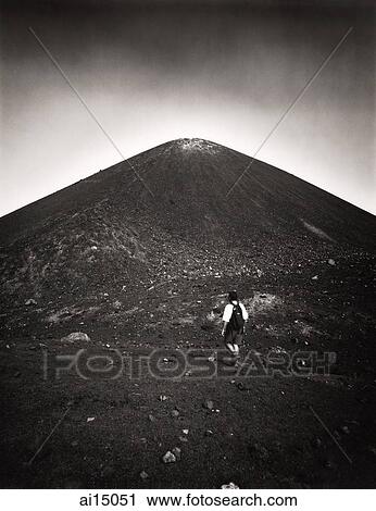 Stock Image - Asian male trekker on slopes of Krakatau volcano. Fotosearch